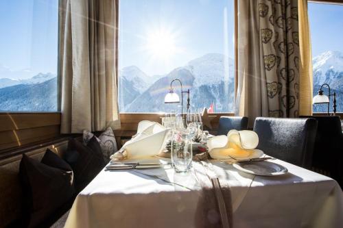 a table in a restaurant with a view of mountains at Meisser Hotel "superior" in Guarda