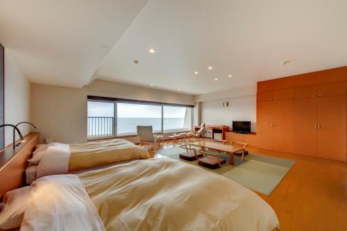 a bedroom with a large bed and a dining room at Kyukamura Ibusuki in Ibusuki