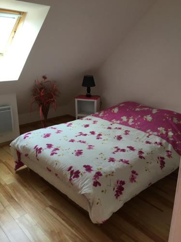 a bed with a white blanket with flowers on it at location appartement in Wissant