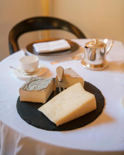 a plate of cheese and bread on a table at Petronilla - Hotel In Bergamo in Bergamo