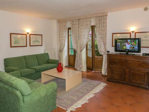Una sala de estar con un sofá verde y un televisor. en Retreat in Siena s Countryside, en Siena