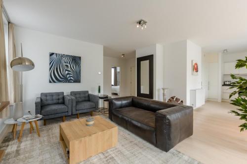 a living room with a leather couch and a table at The Livorno in Brussels