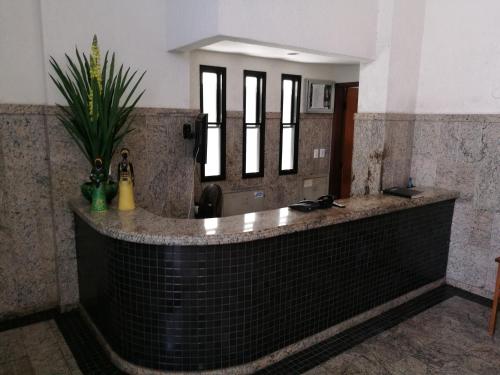 a bathroom with a black tile tub with a mirror at MarAzul Residence in Salvador