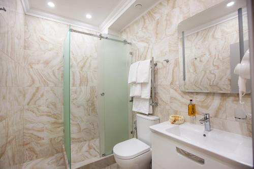 uma casa de banho com um chuveiro, um WC e um lavatório. em ДОНСКОЙ em Rostov on Don