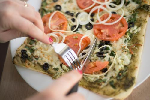 a person eating a slice of pizza with a fork at Le Deville par G5 in Rouyn