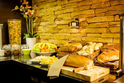 a buffet with bread and other foods on a table at Fletcher Hotel - Restaurant Nieuwvliet Bad in Nieuwvliet-Bad