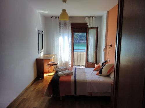 a bedroom with a bed with a view of the ocean at Apartamentos la Pasarela in Villanueva de Arosa