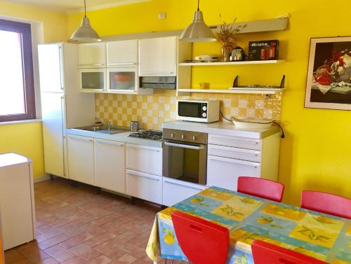 una cocina con electrodomésticos blancos y una mesa con sillas. en Villa Antares en Pesaro