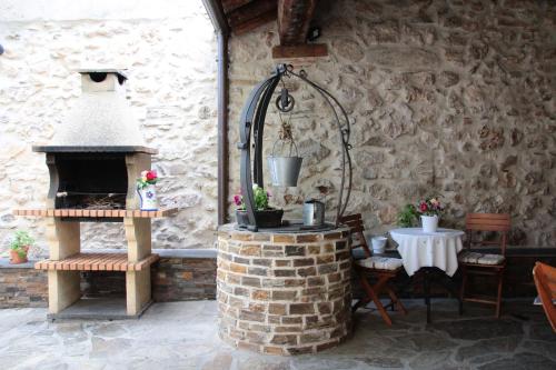 a patio with a brick oven in a stone wall at Casa La Plaza in Armuña