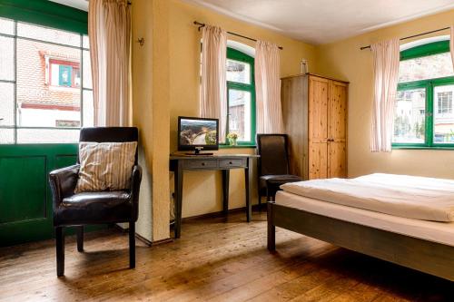 a bedroom with a bed and a desk and a chair at Pension Rauschenstein in Bad Schandau
