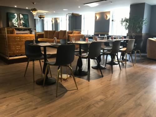 a restaurant with tables and chairs in a room at Mercure Nancy Centre Place Stanislas in Nancy