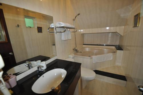 a bathroom with a sink and a toilet and a tub at Hoa Huong Duong Hotel Saigon in Ho Chi Minh City