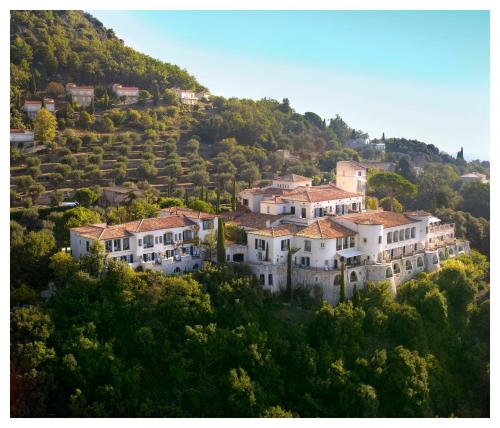 a group of houses on a hill with trees at Ch&acirc;teau Saint-Martin & Spa - an Oetker Collection Hotel in Vence