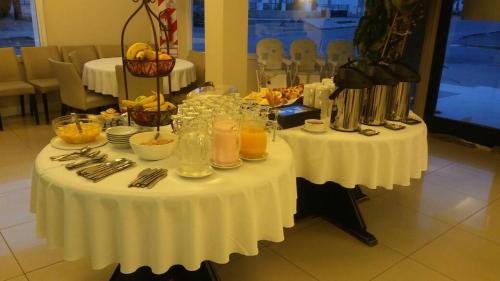 a table with a white table cloth with drinks on it at Hotel Casino Hue Melen in Zapala