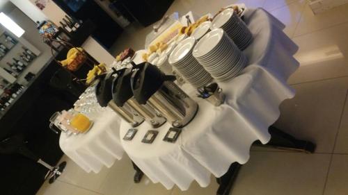 a table with white plates and utensils on it at Hotel Casino Hue Melen in Zapala