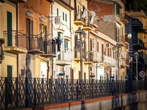 een rij gebouwen met balkons en een hek bij Guest House a Portapalermo in Santo Stefano di Camastra