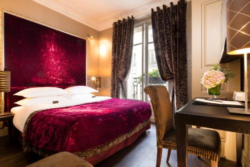a bedroom with a bed with a red headboard and a desk at Hotel Ares Eiffel in Paris