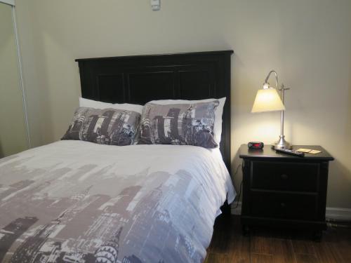a bed with a black headboard and a lamp on a table at Western Hotel & Executive Suites in Guelph
