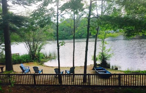 a view of a lake with chairs and a boat at Clear Pond Getaway in Plymouth