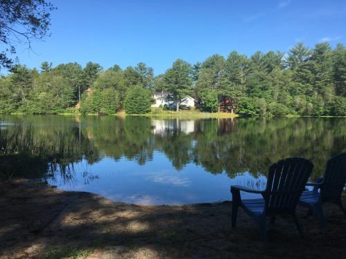 two chairs sitting in front of a lake at Clear Pond Getaway in Plymouth