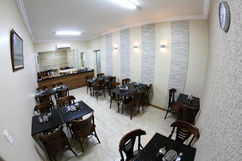 a dining room with tables and chairs in a restaurant at Hotel Belem Fortaleza in Fortaleza