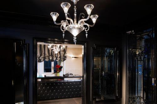 a chandelier hanging in a room with a mirror at Hotel Ares Eiffel in Paris