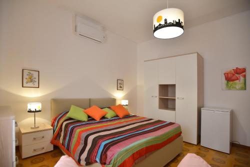 a bedroom with a large bed with colorful pillows at Liberty Guest House in Alghero