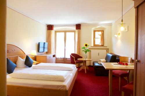 a hotel room with a bed and a living room at Hotel Salzburger Hof in Bergen