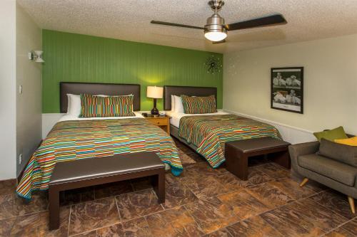 a hotel room with two beds and a couch at Desert Riviera Hotel in Palm Springs