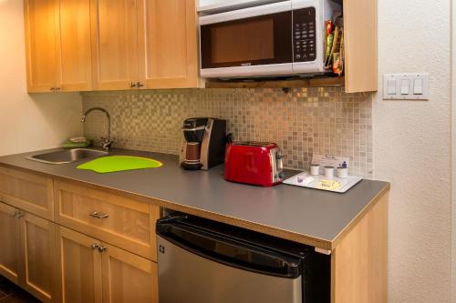 a kitchen counter with a sink and a microwave at Desert Riviera Hotel in Palm Springs