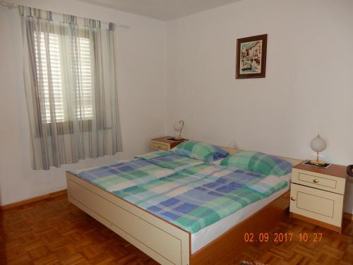 ein Schlafzimmer mit einem Bett und zwei Nachttischen in der Unterkunft Apartments Mandolina - Hiša na samem s pogledom na morje in Žman