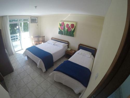 two beds in a room with a view of a bedroom at Hotel Marlin Azul in Iriri
