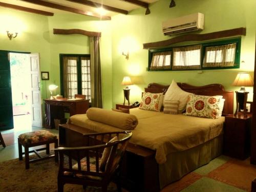 a bedroom with a bed and a chair in a room at Ranjit's Svaasa Amritsar in Amritsar