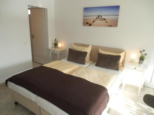 ein Schlafzimmer mit einem großen Bett mit zwei Tischen in der Unterkunft Villa Vogelsang, Schwimmbad, Sauna in Sierksdorf