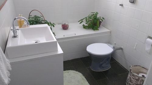 a white bathroom with a toilet and a sink at Luiz & Cristiana Sampaio in Salvador