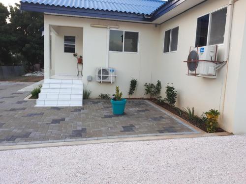 a white house with a blue pot in front of it at The Lush in Willemstad