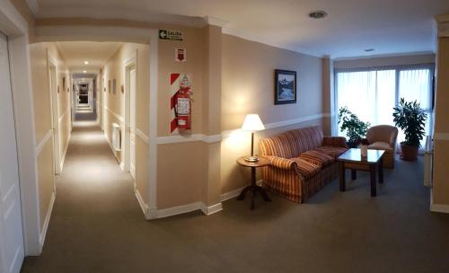 ein Wohnzimmer mit einem Sofa und einem Tisch in der Unterkunft Hotel Kapenke in El Calafate