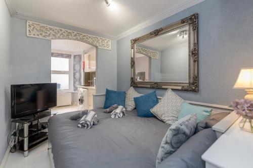 uma sala de estar com um sofá e um espelho em Watford General Suites em Watford