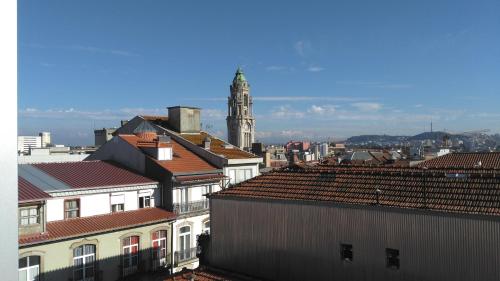 vistas a una ciudad con una torre de reloj y tejados en ML Apartments Almada panoramic balcony, en Oporto