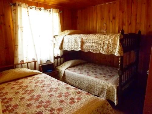 a bedroom with two beds and a window at Cabañas Rupu Lafquén in Pichilemu