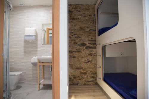 ein Bad mit einem TV an der Wand in der Unterkunft Hostel Cross in Lugo