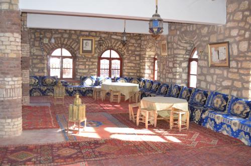 a room with couches and tables in a stone building at Auberge Restaurant Telouet in Telouet