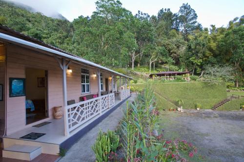 uma casa com um alpendre e um jardim em Barbecue Heritage Gardens Cottage - JM em Newcastle