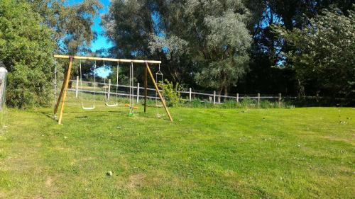 a swing set in the middle of a field at Le moulin de Cohem in Blaringhem
