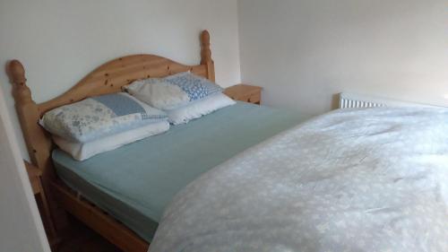 a bed with two pillows on it in a room at Cosy Lakeside Cottage John's hollow in Headford