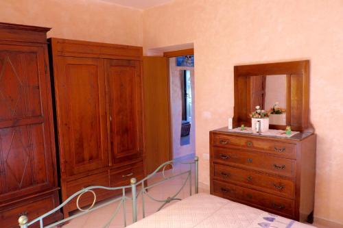 a bedroom with wooden cabinets and a dresser with a mirror at Parcoverdepino in Bastia Umbra