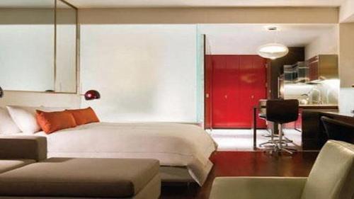 a bedroom with a white bed and a red door at Palms Place Beautiful 51st Floor with Mountain Views in Las Vegas