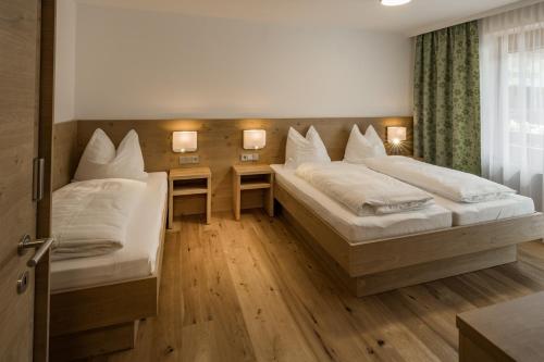 ein Hotelzimmer mit 2 Betten und einem Schreibtisch in der Unterkunft Appartements Hubenhof in Ellmau
