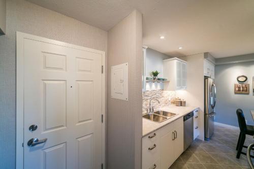 a kitchen with a white door and a sink at McKinnon Pointe #102 in Edmonton