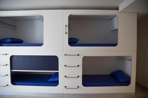 Dois beliches num comboio com almofadas azuis em Hostel Cross em Lugo